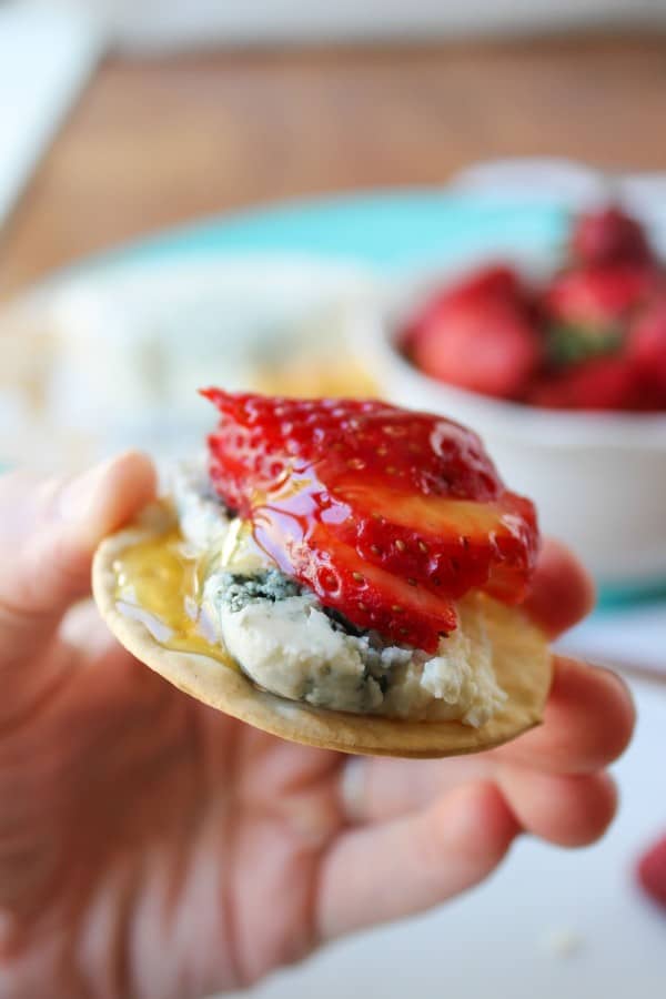 Honey-Drizzled Bleu Cheese Strawberry Bites held in hand.