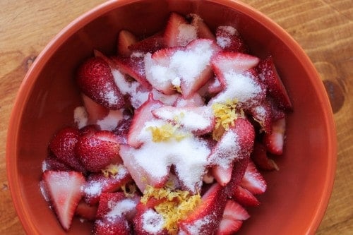 Lemon strawberry mixture in bowl with sugar and zest