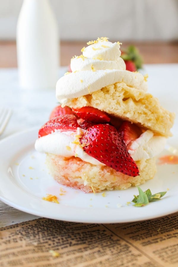 Strawberry Lemon Shortcake stacked on white plate with white and wood background.