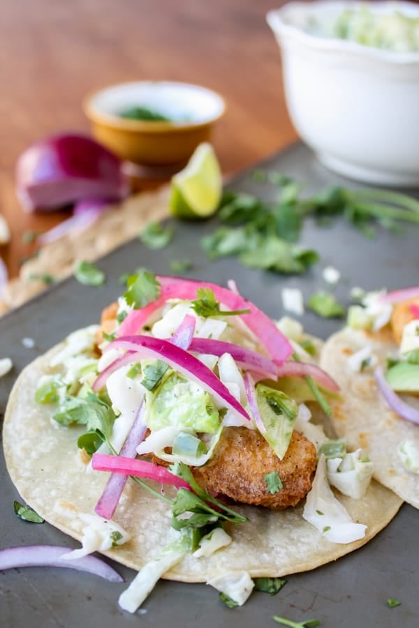 Beer-Battered Fish Taco on cooking pan with red onions.