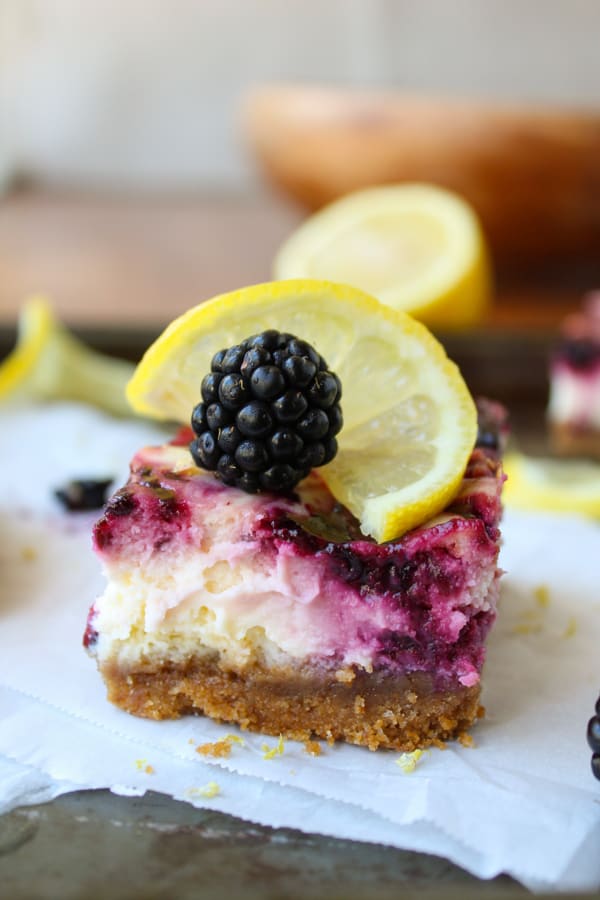 a blackberry lemon cheesecake bar on parchment paper.