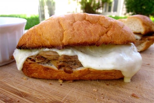 French dip sandwich on cutting board with melted cheese.