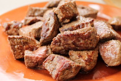 chunks of browned beef on a plate for crock pot beef barley soup.