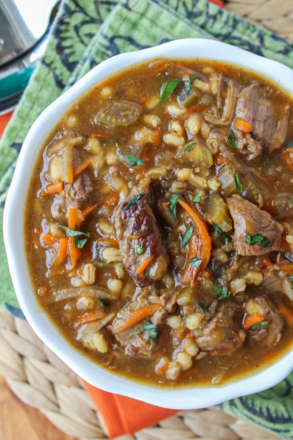 crock pot beef and barley soup in a white bowl.