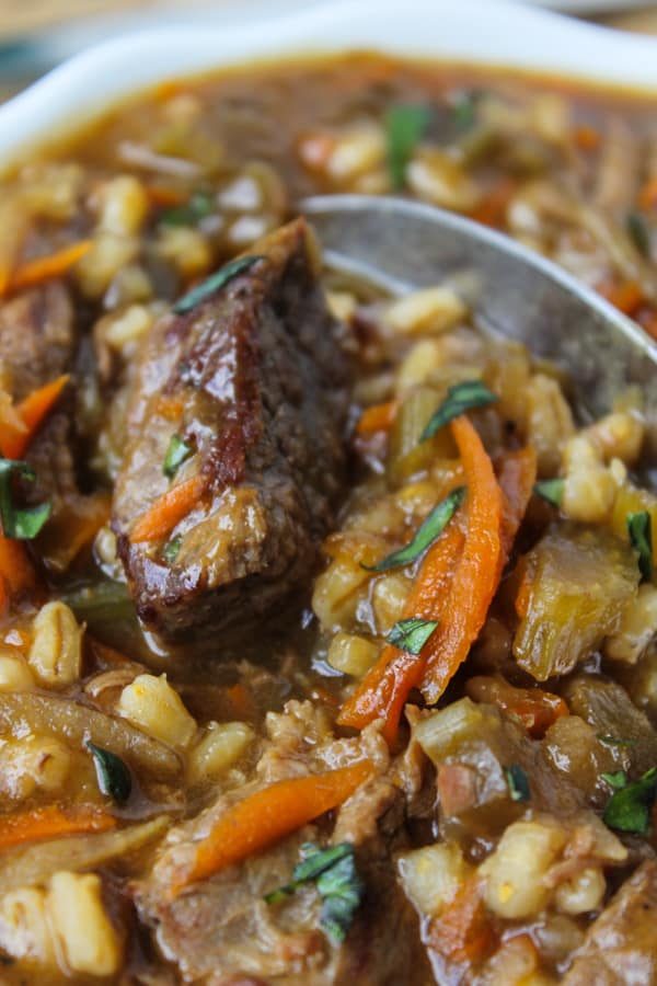 closeup of crock pot beef barley soup recipe in a large pot.