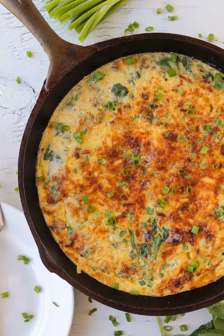 Spinach and bacon frittata in cast iron skillet.