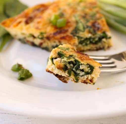 Bite of spinach and bacon frittata on fork