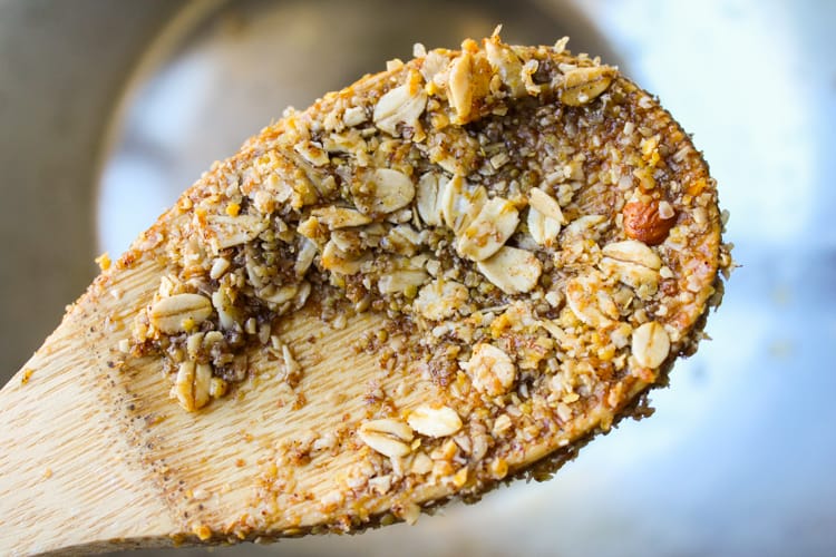 wooden spoon with nuts, oats, and maple syrup from mixing granola.