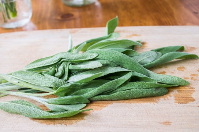 Fresh sage on a wooden cutting board.