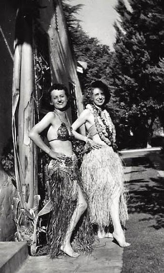 Two military wives in hula skirts and bras on VJ Day.