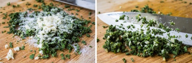 Chopping sage and garlic on a wooden cutting board.