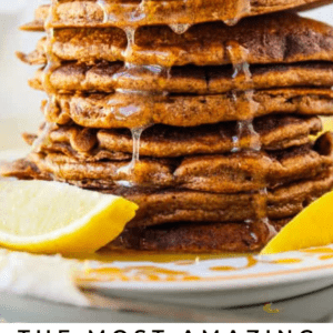 A tall stack of gingerbread pancakes topped with a pat of butter and syrup, with fresh lemon slices on the side. Text at the bottom reads: The most amazing Gingerbread Pancakes - The Food Charlatan.