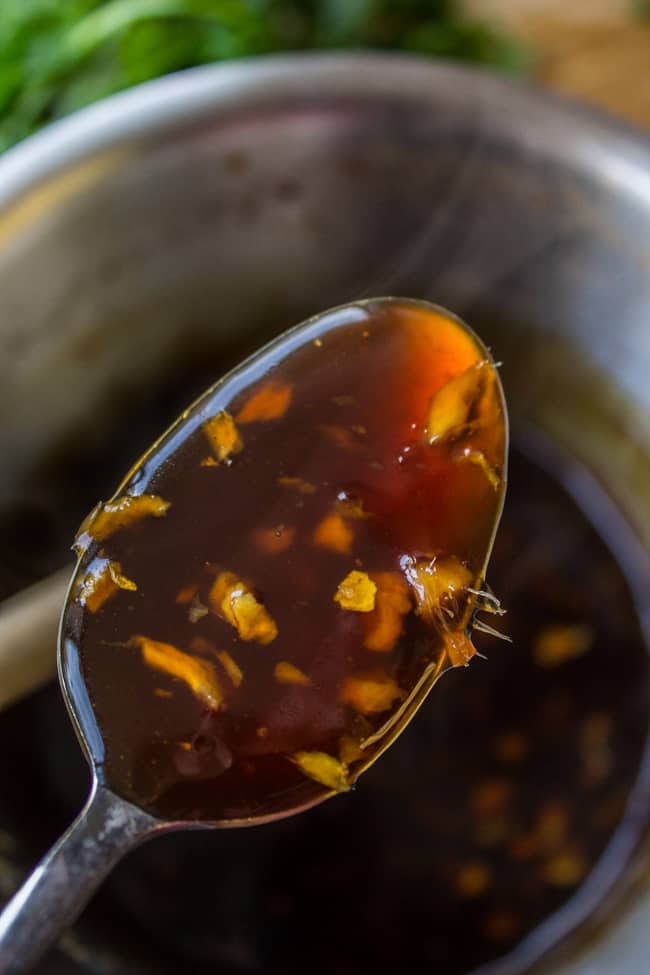 glaze for pork tenderloin on a spoon above a pot.