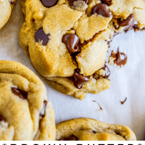 a chocolate chip cookie with a large bite taken out of it on parchment paper.