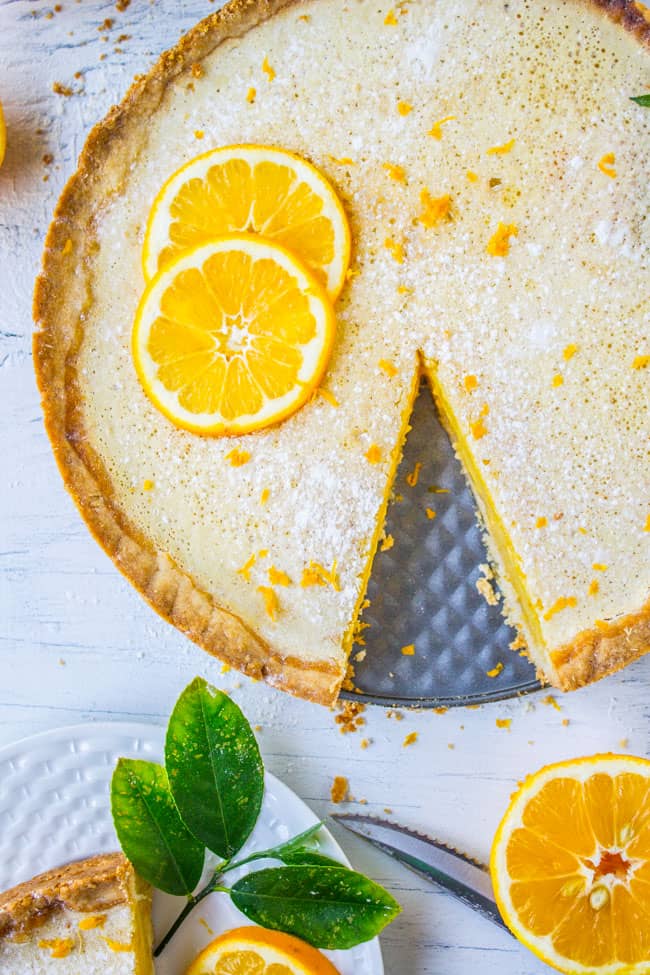 a meyer lemon tart with a slice cut out.