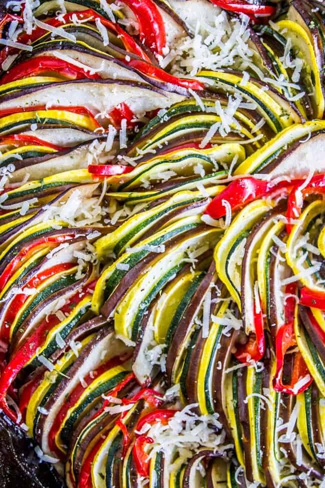 Extreme close up of sliced vegetables in ratatouille sprinkled with grated parmesan.