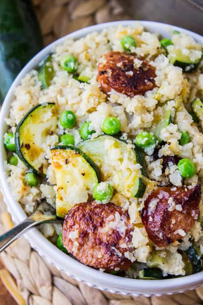 cauliflower rice skillet with zucchini and kielbasa in a white bowl.