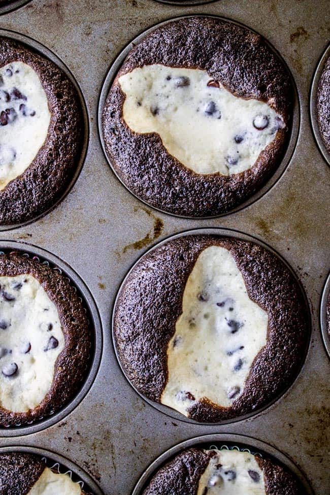 baked chocolate cupcakes with cream cheese filling (black bottom cupcakes) in a muffin tin. 