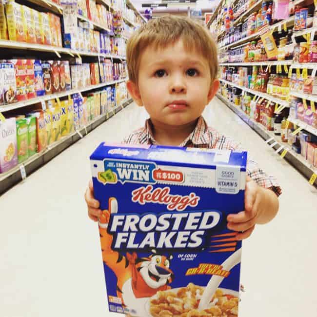 adorable toddler holding a box of cereal.