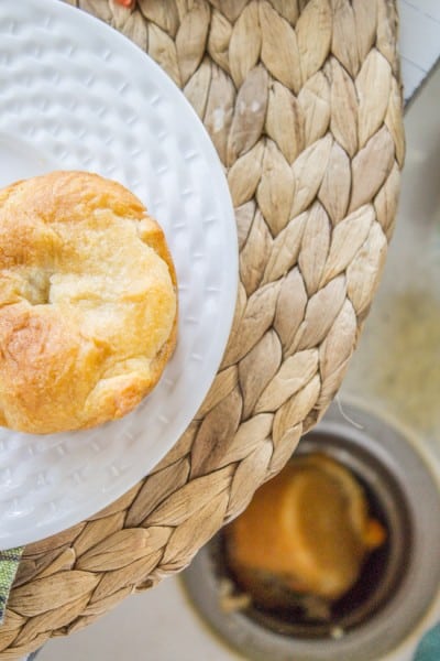 Mini chicken pot pie fallen into sink drain with a mini chicken pot pie on a white plate above it. 