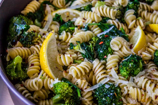 closeup overhead of a pot full of broccoli and pasta with lemons