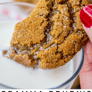 A hand holding a sugar-dusted gingersnap cookie, dipping it into a glass of milk. The text below reads: Gramma Prudys Classic Gingersnaps With the Ultimate Snap! The Food Charlatan.