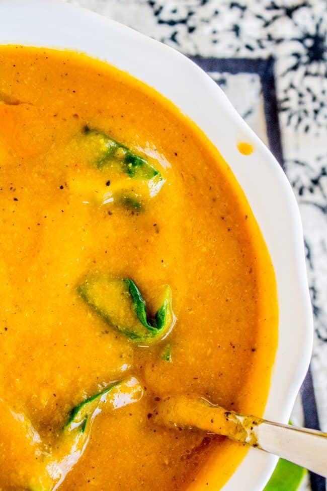 a spoon in a bowl of creamy vegan cauliflower soup.