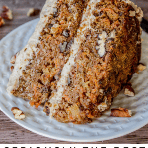A close-up of a slice of carrot cake with maple pecan frosting and visible nuts, served on a white plate. Text below reads, Seriously the Best Carrot Cake with Maple Pecan Frosting, The Food Charlatan.