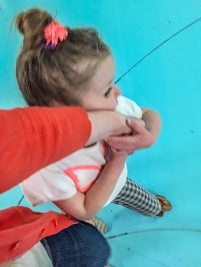 little girl holding her mom's hand, learning how to roller skate.