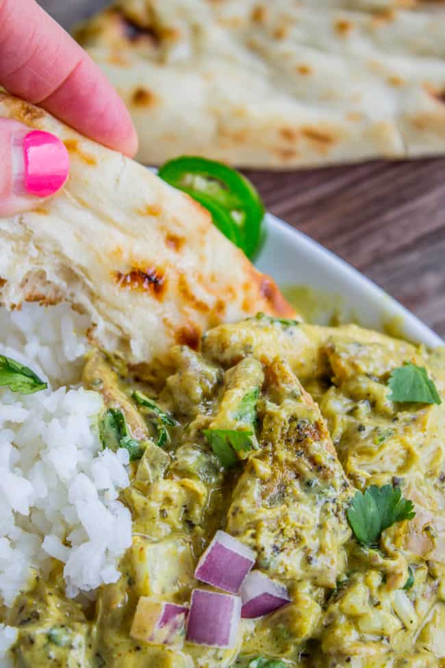 dipping naan in slow cooker basil chicken coconut curry served with rice and cilantro.