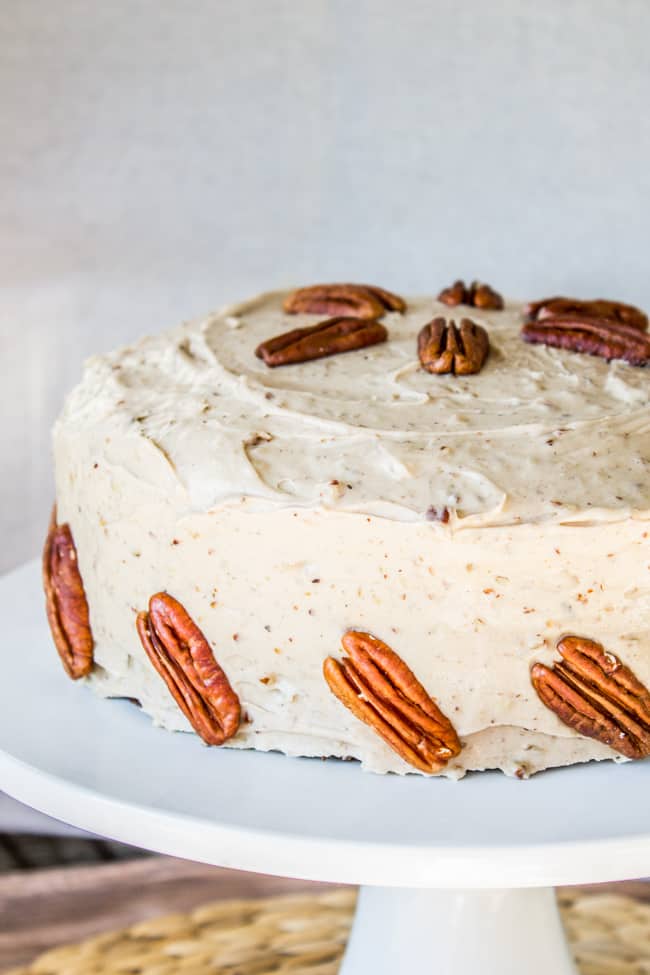 two layer carrot cake with cream cheese maple pecan frosting and large pecans to decorate.