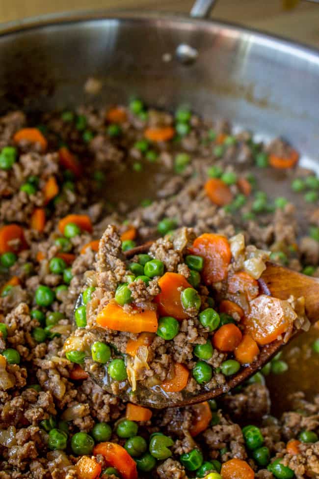 cooking peas, carrots, and onions with ground beef. 