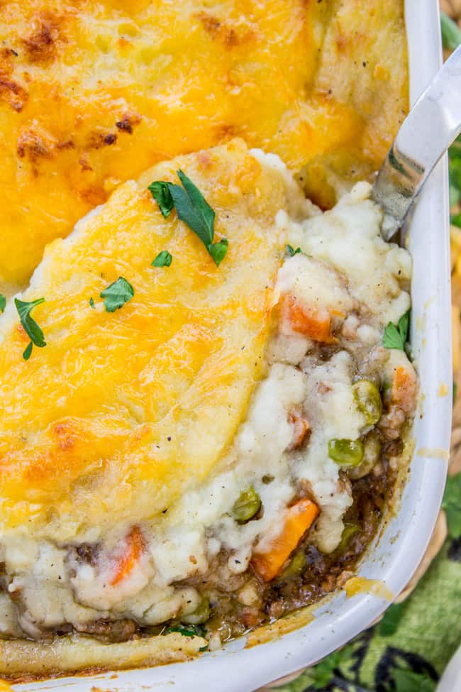 shepherd's pie in a white baking dish with cheese on top.