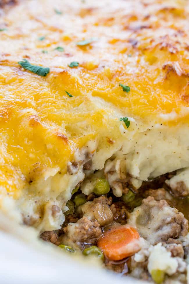 shepherd's pie in a baking dish, showing layers of beef and vegetable filling and cheese-topped mashed potatoes.