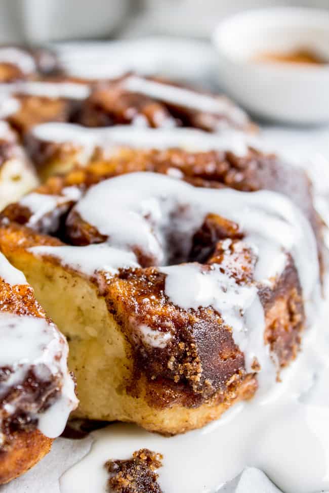 flaky cinnamon rolls gently pulled apart with icing drizzled on top.
