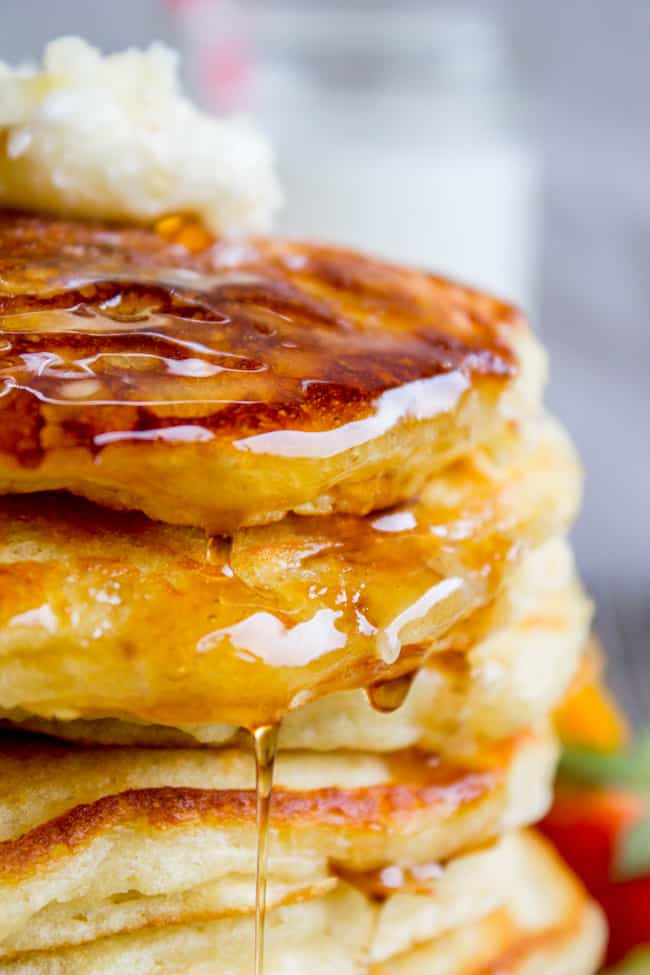 A stack of pancakes covered in butter and syrup. 