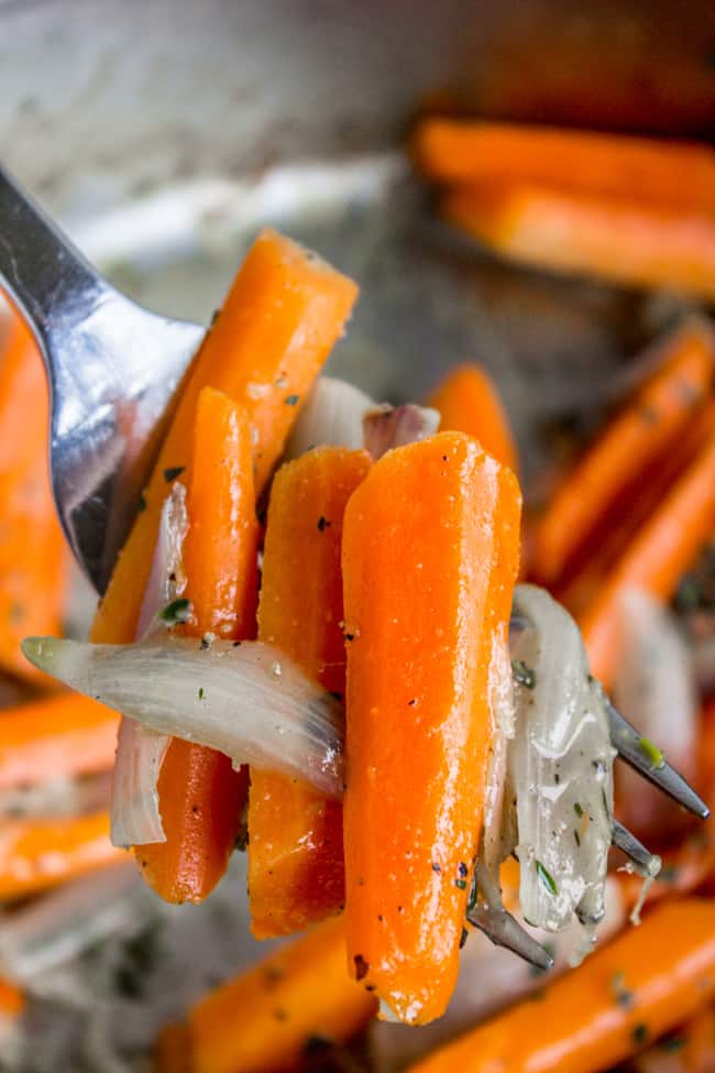 a fork lifting some carrots and shallots.