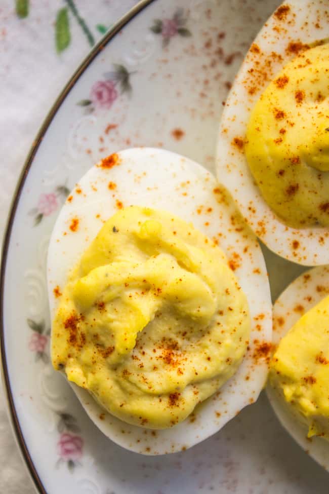 deviled eggs on a vintage floral plate, sprinkled with paprika.