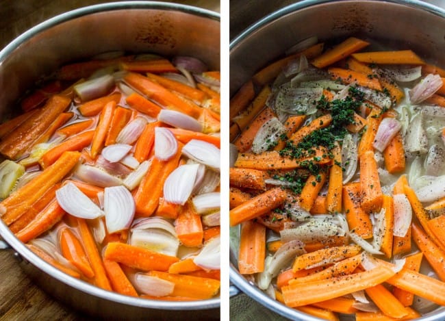 a large metal pot with carrots, shallots, and fresh thyme.