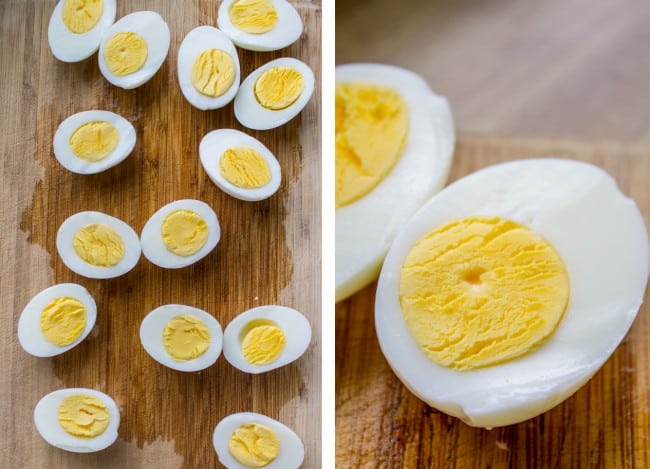 hard boiled eggs perfectly cooked and cut in half to make deviled eggs on a wooden cutting board.