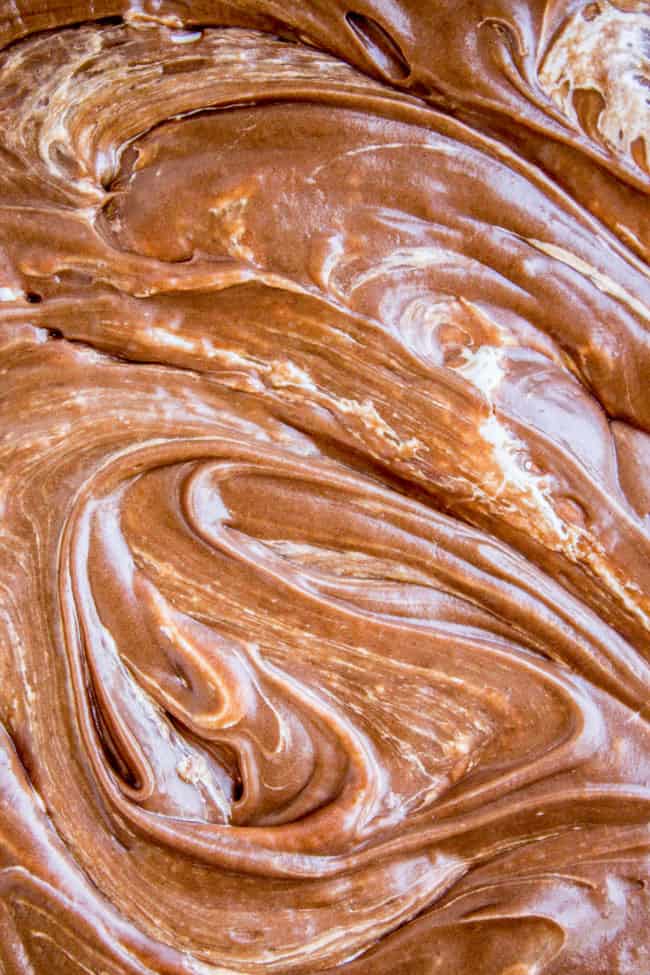 a close up of rich chocolate frosting swirled with marshmallow creme. 