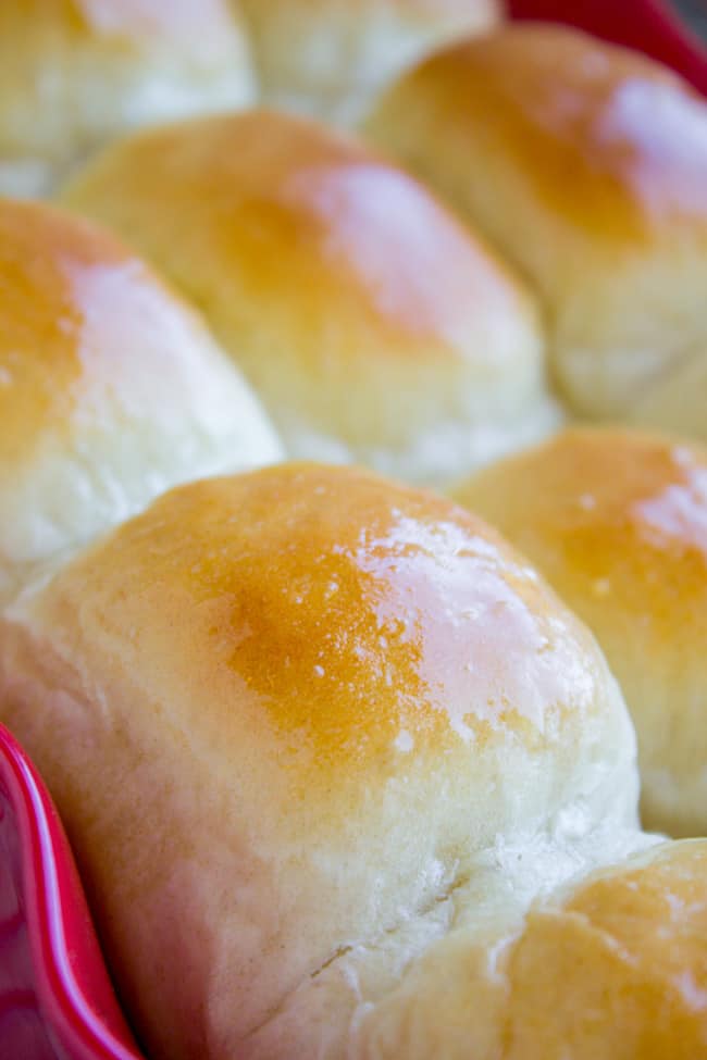 Golden brown buttery dinner rolls in a pan.