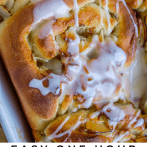 Close-up of honey almond breakfast rolls topped with sliced almonds and drizzled with white icing. Text reads: Easy One Hour Honey Almond Breakfast Rolls. The Food Charlatan breakfast treat.