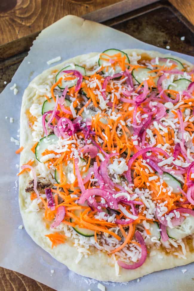 prepared pizza on parchment paper before oven