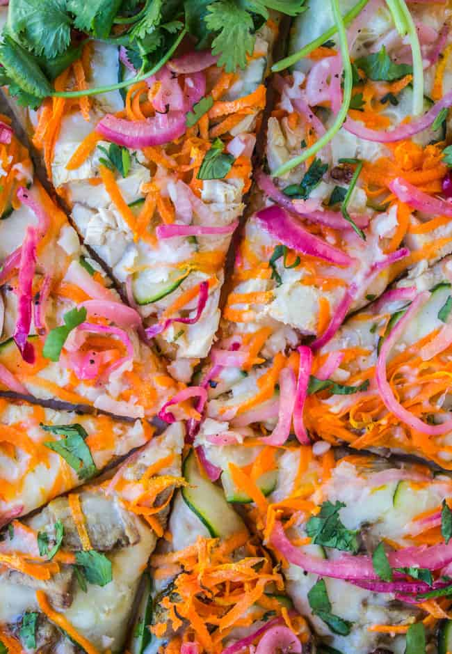Sliced close-up of thai chicken pizza with pickled onions