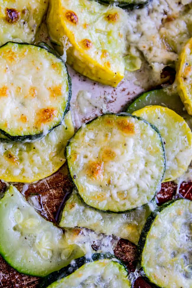 Yellow Squash and zucchini rounds on a pan, topped with crispy parmesan