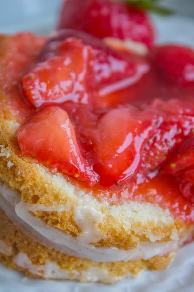 a slice of cream cheese pound cake with vanilla glaze and fresh strawberry topping.