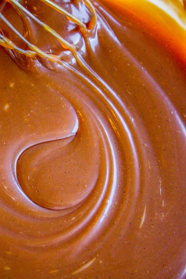 stirring thick caramel sauce with a whisk.