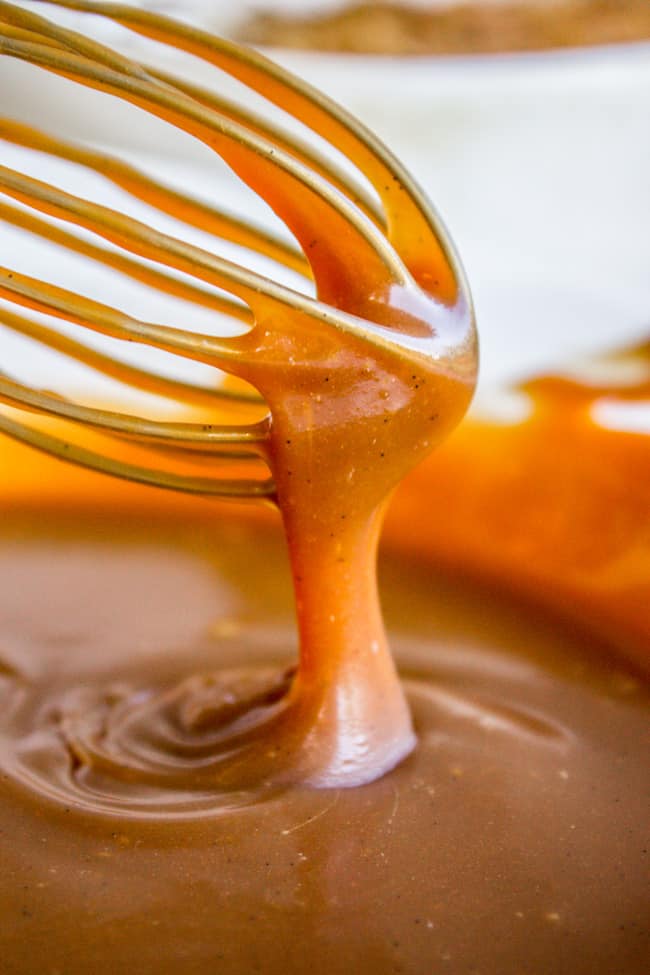 thick caramel sauce pouring off a whisk.