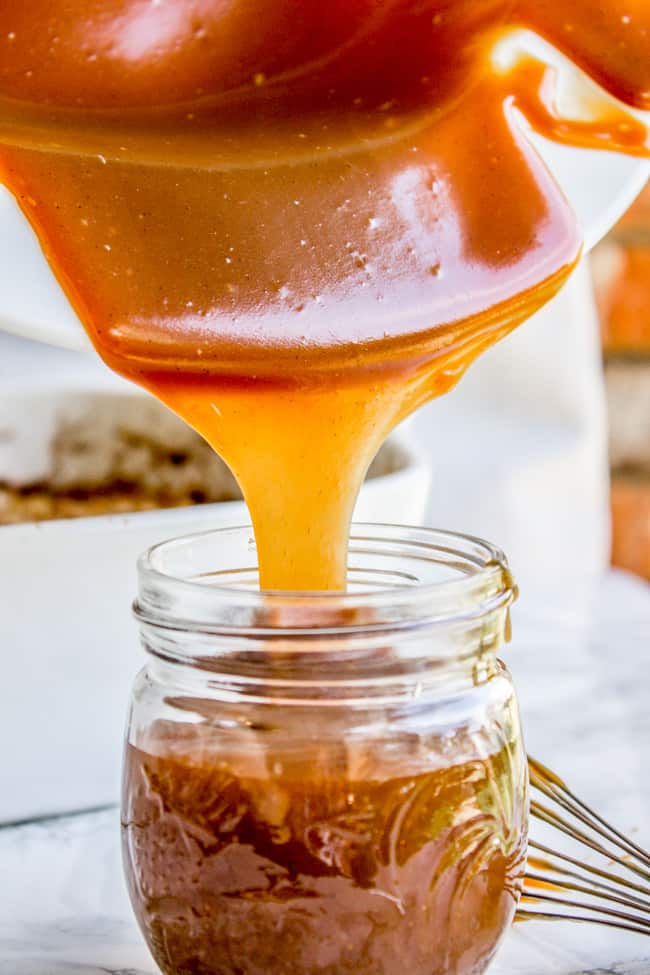 caramel sauce being poured into a mason jar.